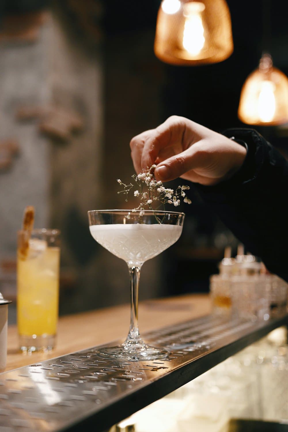 Mixologue décorant un cocktail dans une coupe